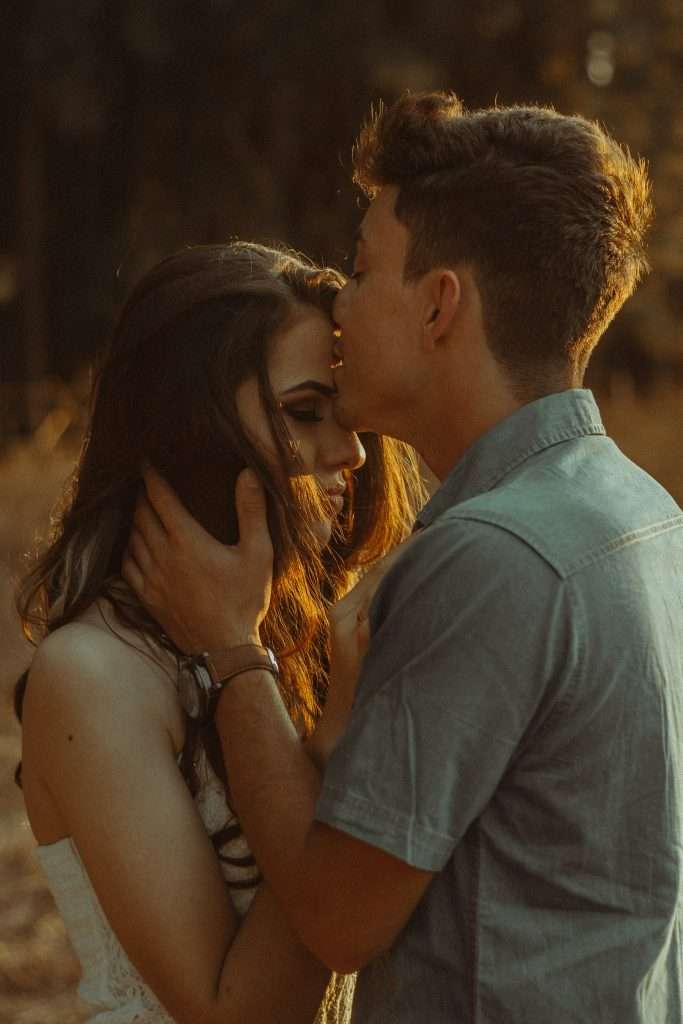 couple, with the man kissing the woman's head.